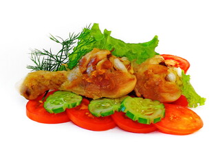 Fried chicken legs with vegetables on white isolated background