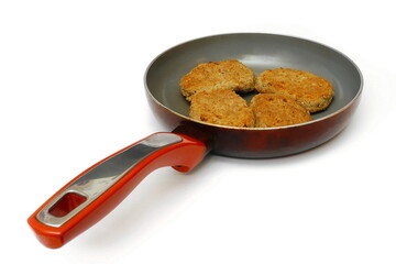 Meat cutlets in a frying pan. Isolate on white.