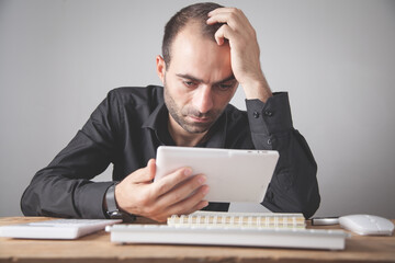 Caucasian businessman looking his digital tablet in office.