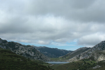 Fototapeta premium A mountain with a lake and clouds in the background (Peaks of Europe, Asturias, Spain)