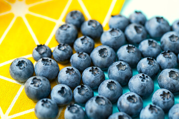 Bilberry on a yellow background, macro image of blueberries on a yellow kitchen textiles