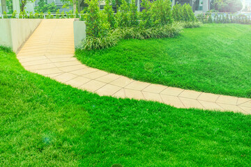 Wheelchair access ramp was built in a park with a bright green lawn, green grass with a disabled path the park landscaping garden design with steep slope trails Designed in the middle of the garden.