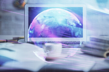 Computer on desktop in office with technology theme hologram. Double exposure. Tech concept.