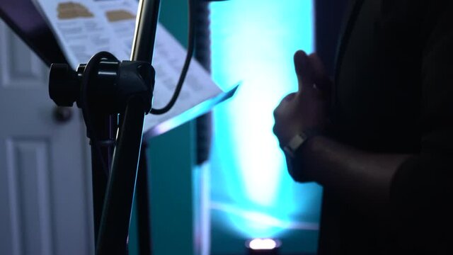 Black rapper recording song in a studio gesticulating with his hands. Hand rapping in a recording studio. Singer memorizes the song