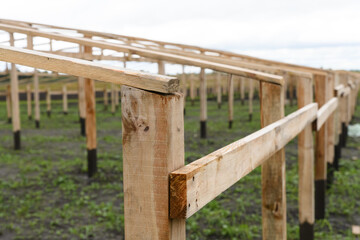 Obraz premium Construction of a wooden greenhouse in the field.