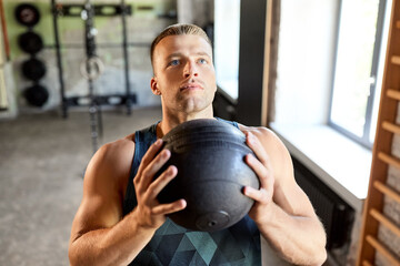 sport, bodybuilding, fitness and people concept - young man with medicine ball in gym