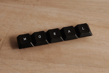 Moral word on black cube with wood background