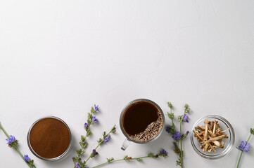 A healthy drink, an alternative to coffee. Chicory drink in a glass cup, dried roots and powder in...