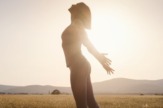 Young Girl Spreading Hands With Joy And Inspiration Facing The Sun