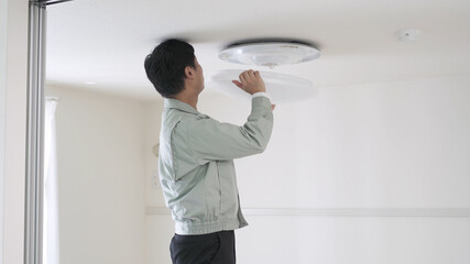 照明器具を取り付ける男性	
