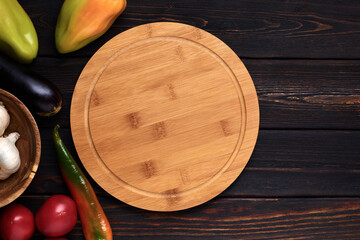 Multifunctional circular wooden cutting board for pizza, bread or steak serve. Top view on wooden...