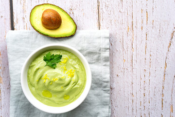 Fresh green cream soup of cucumbers and avocado. Top view