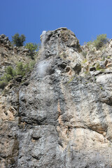 Alanya, TURKEY - August 10, 2013: Travel to Turkey. Waterfalls. Waterfall system. High cliffs, mountains and hills. Clear blue sky.