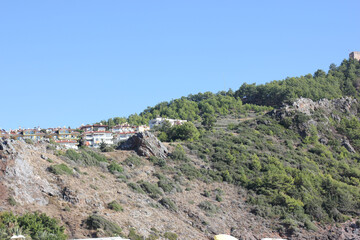 Alanya, TURKEY - August 10, 2013: Travel to Turkey. Helene Hills. Mountains in the background in the distance. Rocks, wildlife of Turkey. Forest and clear blue sky.