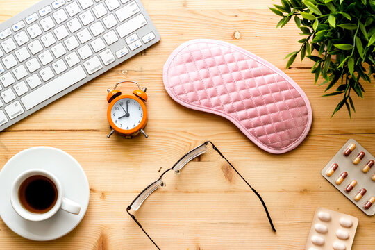 Flat Lay Of Sleep Mask On Wooden Office Desk From Above