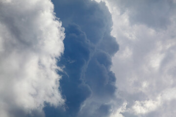 Telephoto closeup photo of dramatic clouds at blue sky
