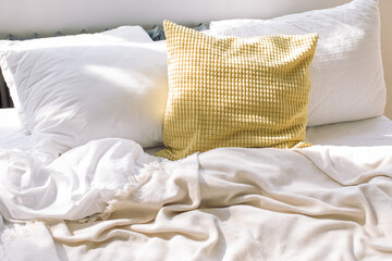 Comfortable bedroom unmade white linen and pillow after sleep with sun light in the morning.
