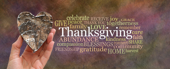 Put some love into Thanksgiving Word Cloud concept - hand holding a rustic brown wooden heart...