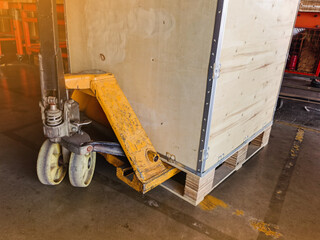 Worker driving forklift loading and unloading shipment carton boxes and goods on wooden pallet from container truck to warehouse cargo storage in logistics and transportation industrial 