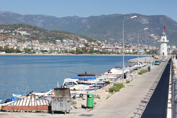 Fototapeta na wymiar Alanya, TURKEY - August 10, 2013: Travel to Turkey. Berth with boats, boats and yachts. Clear blue sky. The waves of the Mediterranean Sea. Water surface.