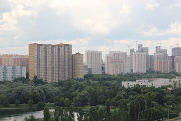 Fototapeta na wymiar Multicolored multi-storey buildings near the lake. Urban landscape