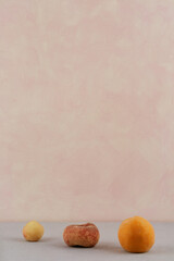 minimalist photo with three fruits on a pink background