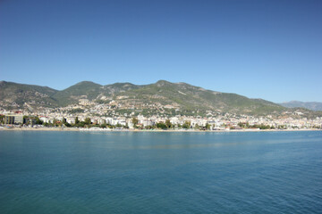 Fototapeta premium Alanya, TURKEY - August 10, 2013: Travel to Turkey. Greenery. Flowers. Green hills. The mountains. Rocks, wildlife of Turkey. Forest and clear blue sky. The waves of the Mediterranean Sea. Water surfa