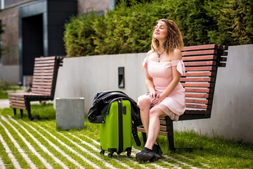 girl with a suitcase on the street. Girl with a suitcase goes on vacation. Girl with a suitcase...