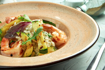 Italian risotto with shrimps and zucchini in a ceramic plate