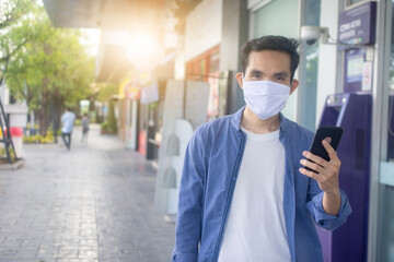Man wearing face mask using mobile phone lifestyle new normal keep social distancing to protect coronavirus pandemic in round two.