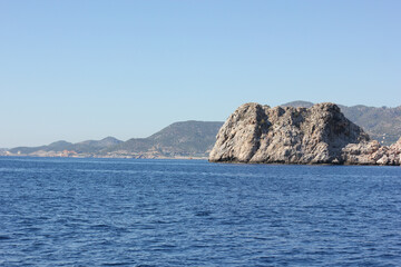 Fototapeta premium Alanya, TURKEY - August 10, 2013: Travel to Turkey. The waves of the Mediterranean Sea. Water surface. Mountains and hills on the coast of Turkey. Green hills.