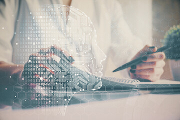 Multi exposure of writing hand on background with brain hologram. Concept of self learning.