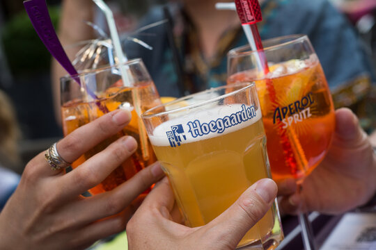 Mulhouse - France - 23 July 2020 - closeup of glasses of alcoholic beverages in hands at the terraceof restaurant
