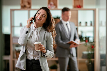 Businesswoman talking to the phone. Happy young woman working in office.	