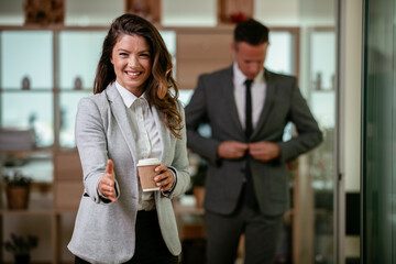 Portrait of beautiful businesswoman in office. Young businesswoman handshaking in office.	