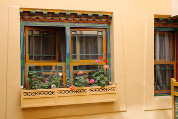 Painted window in traditional Tibetan style and the flowers in Lhasa, Tibet, China