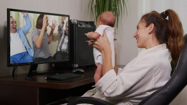 mother and baby having video chat with grandfather using smartphone waving at newborn infant enjoying family connection.