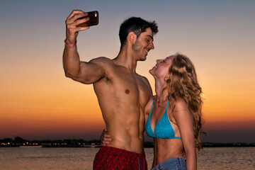Fototapeta premium young couple take selfie in the sunset light