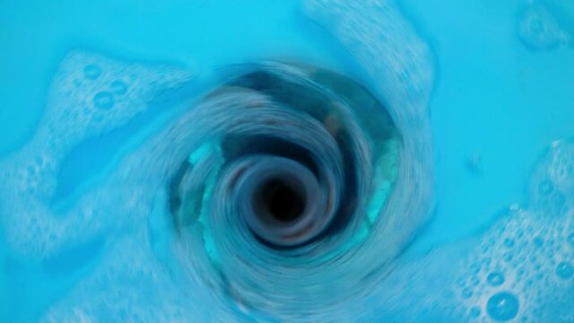 a blue colored water drops into the water drain