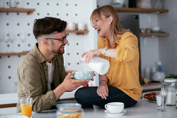 Happy couple eating breakfast at home. Husband and wife enjoying in the morning.	