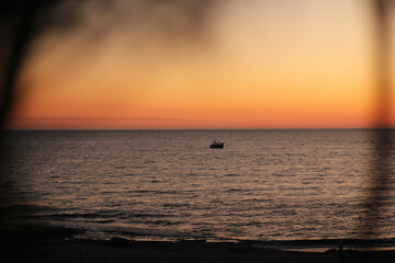 Fototapeta premium Parasailing. Active type of recreation at the sea. Parachute flights behind a boat at sunset.