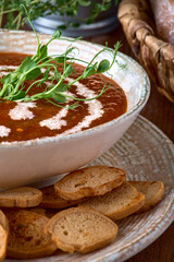 Bowl of gazpacho, bread and vegetables on a table. Tasty Spanish vegan soup
