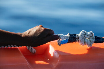 hand of black Migrant detail on boat