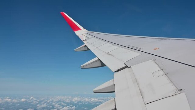 4K View of airplane wing flying during day over Bangkok city