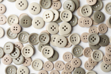 Obraz premium Many grey sewing buttons on white background, closeup