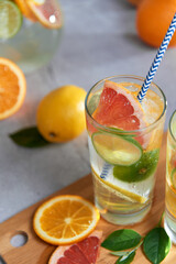 Health care, fitness, healthy nutrition diet concept. Fresh cool homemade citrus infused detox water with grapefruit, orange, lemon and lime and ice in a jug and glasses for spring summer days.