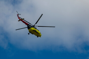 A yellow ambulance helicopter with red crosses transports seriously ill people from remote areas of Siberia