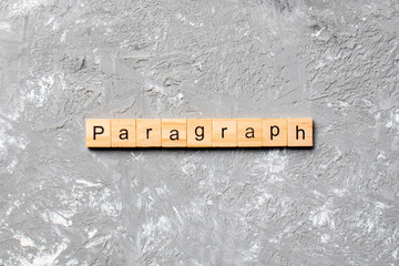 paragraph word written on wood block. paragraph text on table, concept