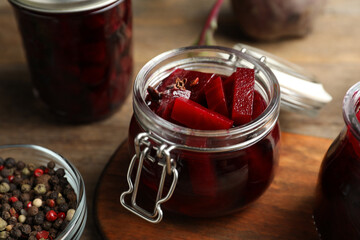 Delicious pickled beets and spices on wooden table, closeup