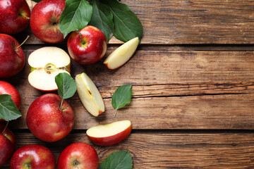 Ripe juicy red apples on wooden table, flat lay. Space for text